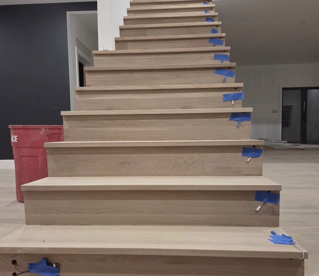 Custom white oak staircase during installation by Ferreira's Flooring