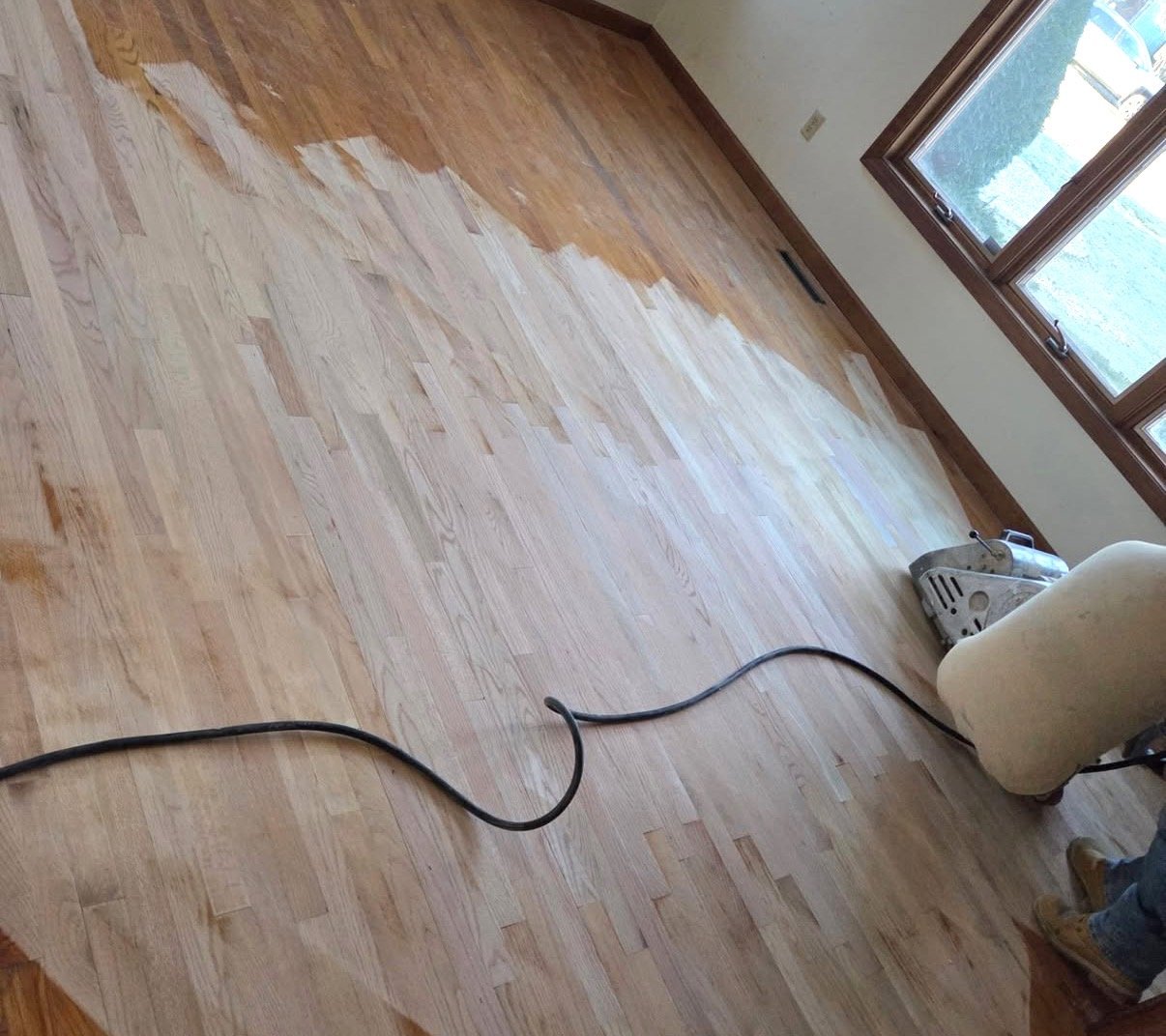 Refinishing job mid-progress — old finish on one half, freshly sanded wood on the other